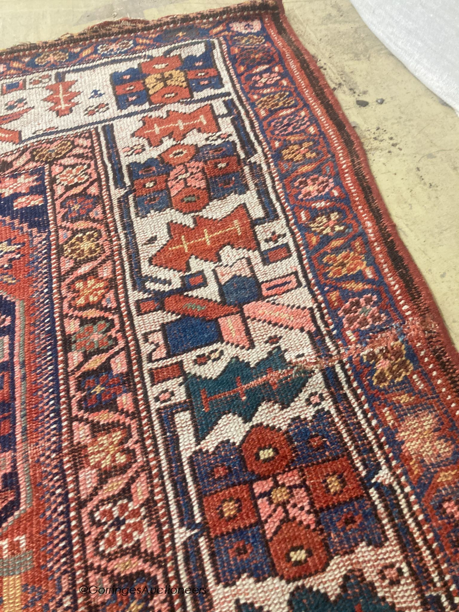 A Caucasian red ground rug, 218 x 112cm